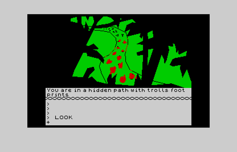 The forest path with troll footprints on the Atari ST in ZX Spectrum mode: a green scene of tangled trees with red troll footprints leading up the path, the room text and command console below.